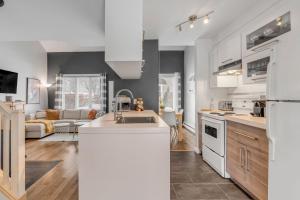 a kitchen with white appliances and a living room at Initial / Renard / MSA in Beaupré