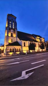 a church with a clock tower on the side of a street at Appartement entièrement rénové proche de Paris in Créteil