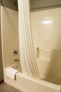 a bathroom with a shower with a white shower curtain at 2 bedroom condo at Wild Eagle Lodge, #133 in Eagle River