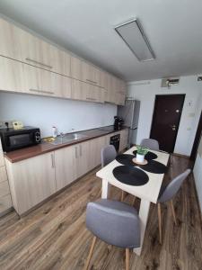 a kitchen with a table and chairs in a room at Milan Apartament-in the center of Târgu Mureș in Târgu-Mureş