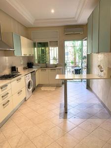 a large kitchen with a table in the middle at Le luxe de Sidi Bou Saïd in Sidi Bou Saïd
