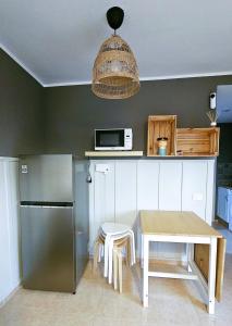 a kitchen with a table and a stainless steel refrigerator at Blue Oasis in Corralejo