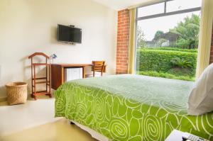 a bedroom with a green bed and a window at Gran Hotel de Lago - Shushufindi in Shushufindi +48 photos