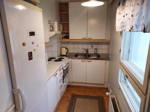 a kitchen with white cabinets and a white refrigerator at Apia Super Stay, Sauna, 5pers in Valkeakoski