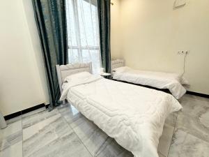 two beds in a room with a window at Diamond apartments, شقق الماس الحديثة- حي القادسية اليرموك in Baghdad +40 photos
