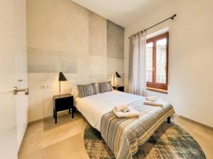 a bedroom with a large bed and a window at Can Bona Casa - Apartamento con vistas a la plaza in Besalú