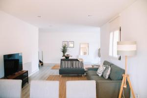 a living room with a couch and a tv at Just Like Home - Casa Rosa in Padornelo