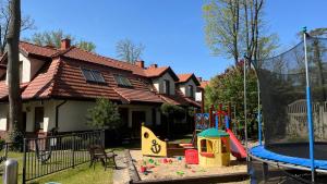 a house with a playground in front of a house at Apartamenty PRIMA in Rewal