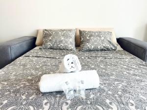 Una cama con una toalla y dos vasos. en Prestige apartment, en Lugano