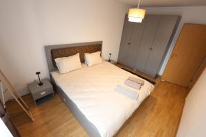 a bedroom with a large bed with white sheets and pillows at Central Prime Apartments 09 in Pristina