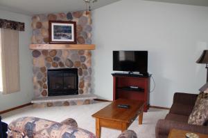 a living room with a fireplace and a tv at 2 Bedroom Condo at Wild Eagle Lodge, #232 in Eagle River