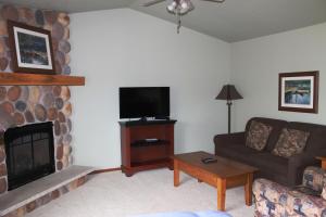 a living room with a couch and a fireplace at 2 Bedroom Condo at Wild Eagle Lodge, #232 in Eagle River