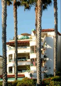 a white building with palm trees in front of it at Casa Tropicana in San Clemente