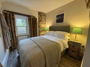 une chambre avec un lit et une fenêtre dans l'établissement Prior Hall Farm Cottage - 3 bedroom luxury cottage in center of Malham, à Malham