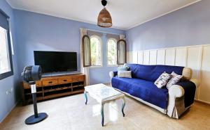 a living room with a blue couch and a flat screen tv at Blue Oasis in Corralejo