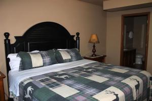 a bedroom with a bed with a plaid blanket at 3 Bedroom condo at Wild Eagle Lodge in Eagle River