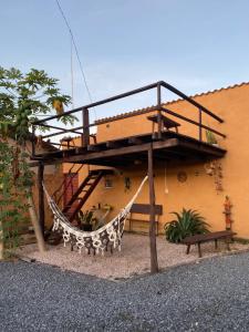 a hammock in front of a house with a building at Chalé Canarinho in Colinas Do Sul