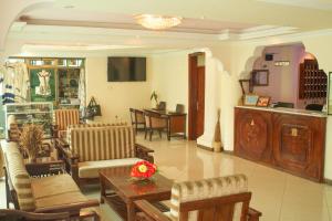 貢德爾的住宿－AG Hotel Gondar，客厅配有椅子和鲜花桌子