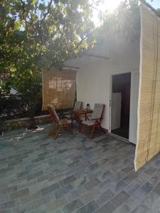 a patio with chairs and a table and a tent at Apartmani Vrzić in Baška