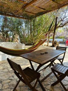 a hammock and a chair and a table with a hammock at Cinque Tomoli SINTROPICA in Ventotene +8 photos