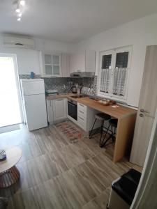 a kitchen with a white refrigerator and a wooden floor at Apartmani Vrzić in Baška
