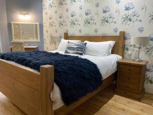 una camera da letto con un letto grande con una coperta blu di La Montgrande Bed & Breakfast ad Aulnay Altre 17 foto