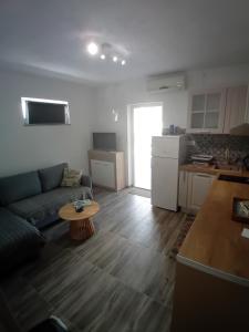 a living room with a couch and a table at Apartmani Vrzić in Baška