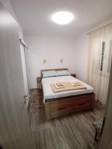 a bedroom with a bed in a white room at Apartmani Vrzić in Baška