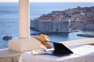 mesa con ordenador portátil y vistas a la ciudad en Adriatic View Studio Apartments, en Dubrovnik