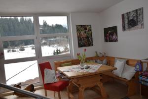 a dining room with a table and a large window at Ferienwohnungen Ellmer in Flachau