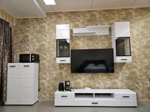 a living room with a tv and white cabinets at Hotel Ilomantsi North Star in Ilomantsi