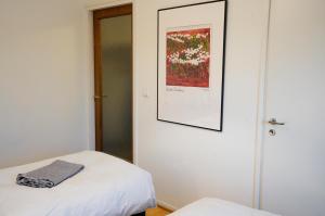 a room with two beds and a picture on the wall at Cozy apartment with view in Kajaani