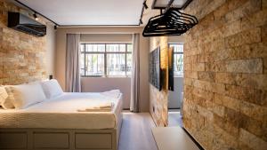 ein Schlafzimmer mit einem Bett und einer Ziegelwand in der Unterkunft Studio de Luxo Urban in Brasilia