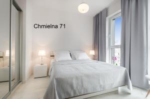 biała sypialnia z łóżkiem i oknem w obiekcie Twój Salon-Apartamenty Stare Miasto w Gdańsku