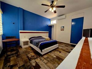 a blue bedroom with a bed and a ceiling fan at Luna Azul in Tapachula
