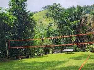 a volleyball net in a park with a bench at Sítio Donana Sana in Macaé