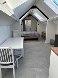 a room with a bed and a table and chairs at Chez MJ in Pont-à-Celles