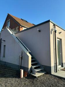 a house with a staircase leading up to a building at Chez MJ in Pont-à-Celles