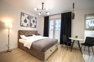 凯尔采Central Luxury&Gold Apartments , Parking GRATIS FaktVat的一间卧室，里面有一张床、一张桌子和几把椅子。 更多78张照片