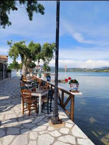 a row of tables and chairs next to a body of water at Villa Garden and Sea Lefkada in Lygia