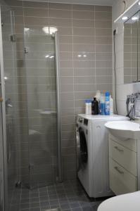 a bathroom with a shower and a washing machine at A two-bedroom with river view in Kajaani +13 photos
