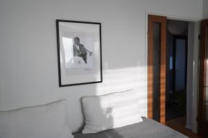a picture of a woman playing a guitar on a wall at A two-bedroom with river view in Kajaani