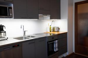 a kitchen with a sink and a stove top oven at A two-bedroom with river view in Kajaani