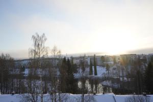 a winter view of a city with snow and trees at A two-bedroom with river view in Kajaani