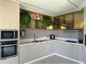 a white kitchen with a sink and a microwave at Studio Aeroporto in Teresina