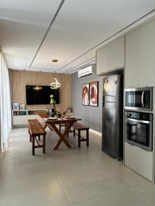a kitchen with a table and a refrigerator at Studio Aeroporto in Teresina +3 photos