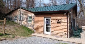 a log cabin with a green roof at High Ridge Cabin with Hot Tub, Starlink Wi-Fi & Whole-House Generator in Stanley