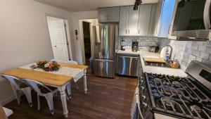 a kitchen with a table and a sink and a stove at High Ridge Cabin with Hot Tub, Starlink Wi-Fi & Whole-House Generator in Stanley +10 photos