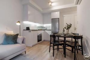 a living room with a table and a couch and a kitchen at ViVi Homes - Anemona , Beach , Balcony, Centre in Fuengirola