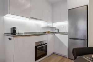 a kitchen with white cabinets and stainless steel appliances at ViVi Homes - Anemona , Beach , Balcony, Centre in Fuengirola +9 photos